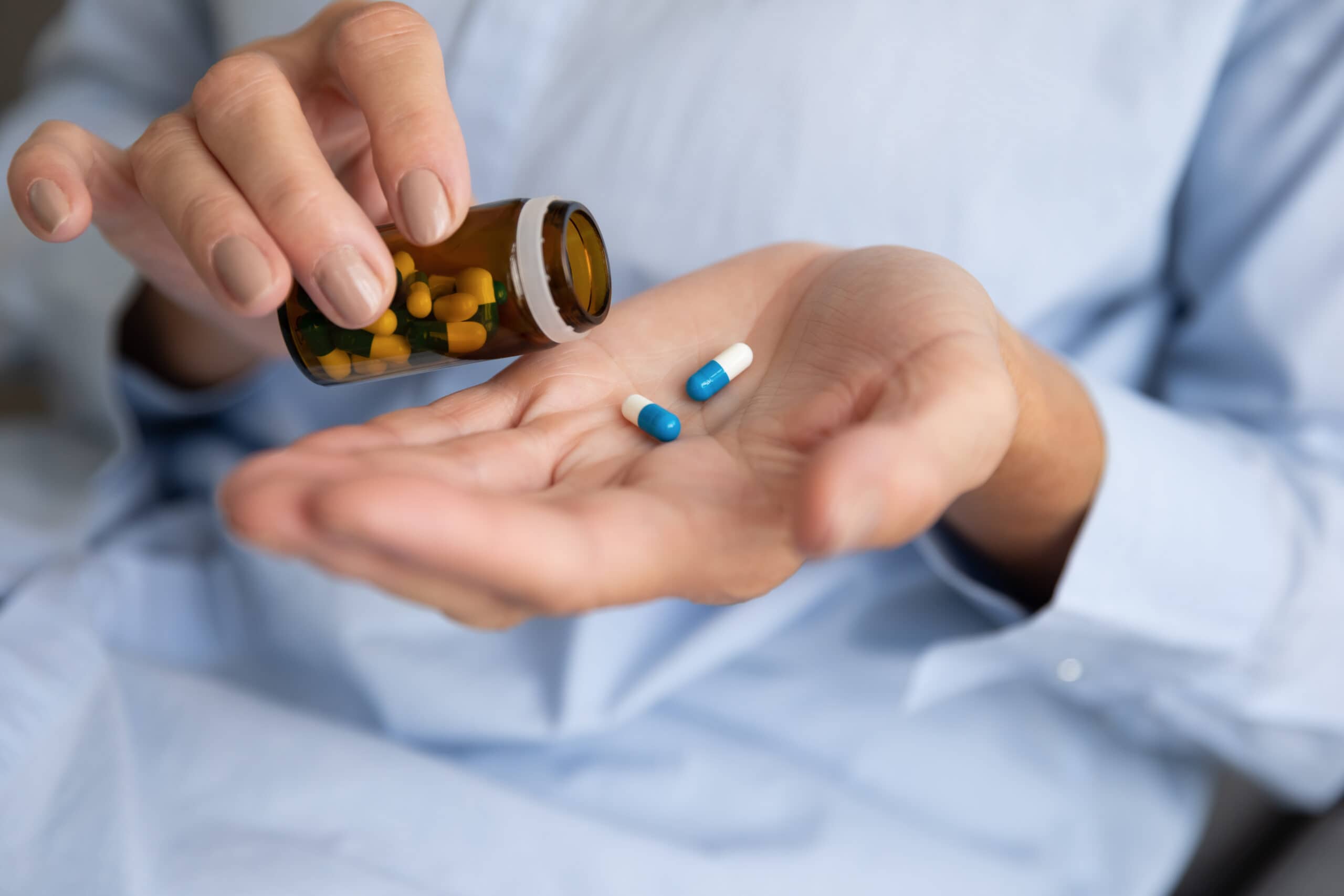 Elderly,sick,ill,woman,hold,two,pills,on,hand,pouring